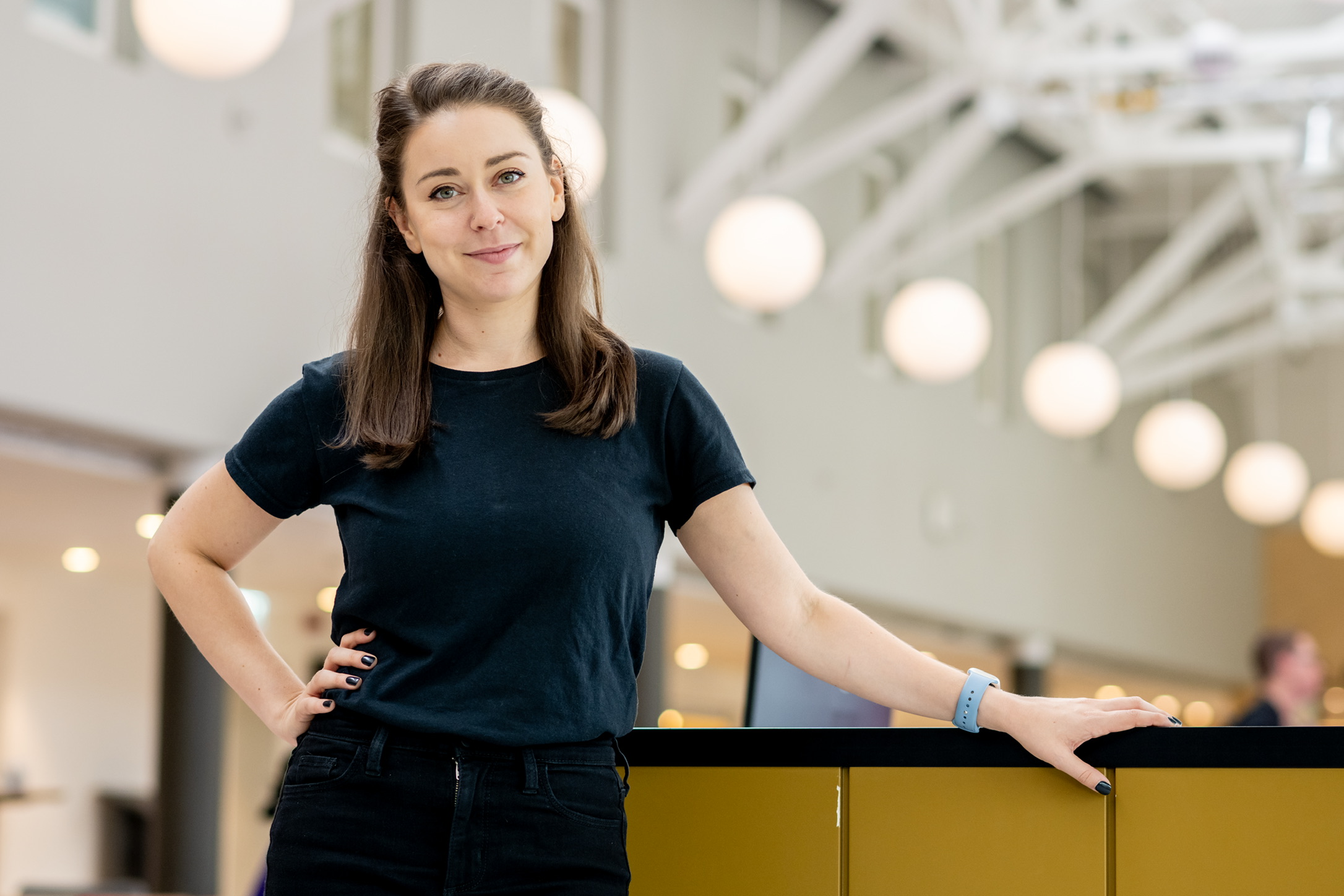 Jessie posing for a portrait at a conference, in all black as is her vibe.